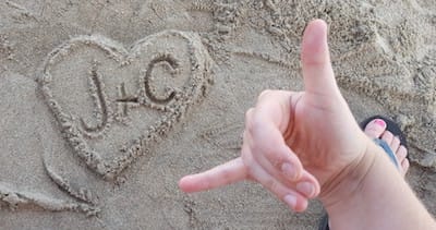 Sand art at the beach: a heart with "J+C" written in it