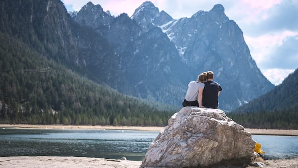 Couple on rock looking at a lake