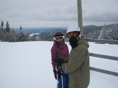 A couple of skiers on the top of a hill