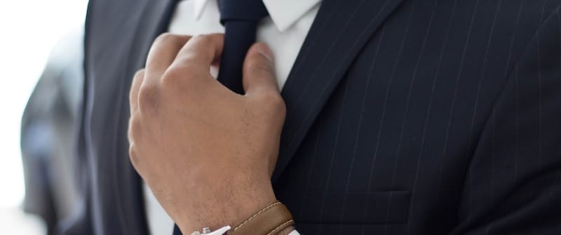 Man in business suit adjusting tie