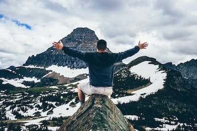 Man on top of a mountain celebrating the view