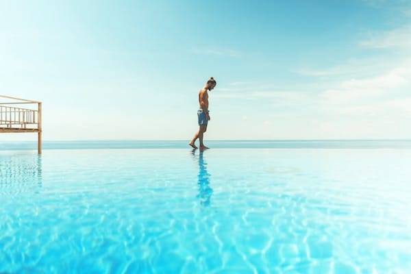 Man walking on edge of pool - appearing as though he's walking on the water