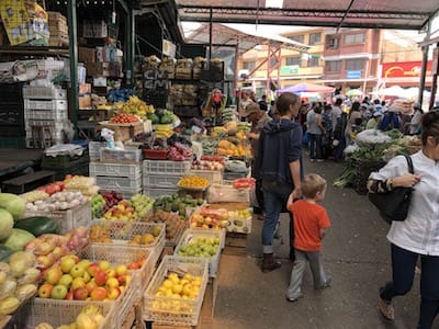 Ellen and one of her children walking in a market