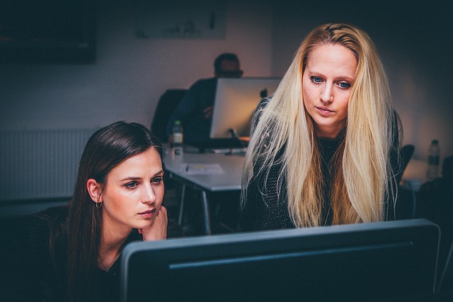 Two women working on a computer together